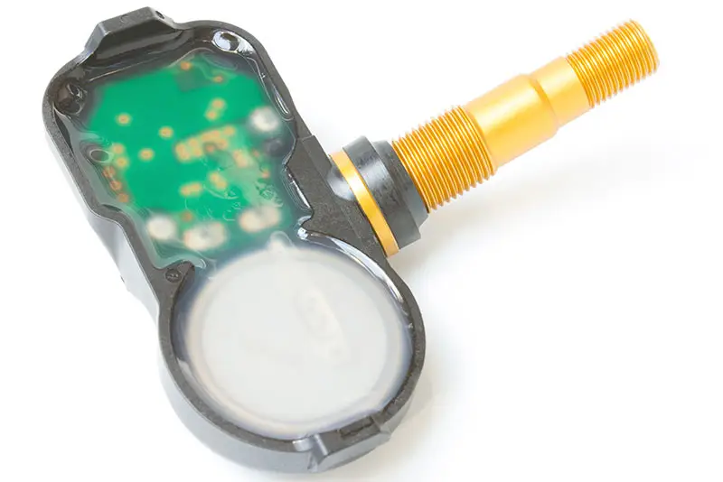 Close up view of a tire pressure sensor embedded into a valve stem.